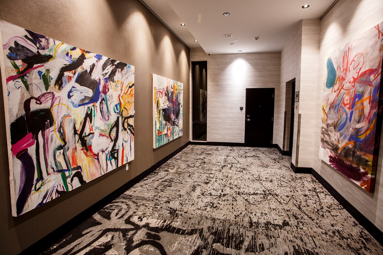 Beautiful private entrance in a decorated hallway filled with custom art and black and white carpet