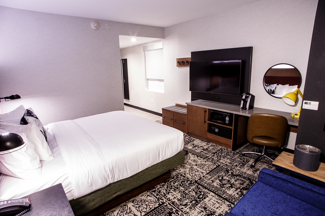 King bed with television, small desk for work, and a chair at Hotel Rock Lititz