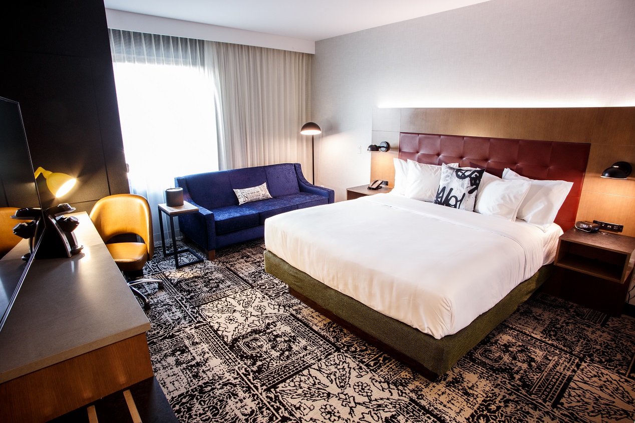 Hotel Rock Lititz's hotel room with a beautiful king bed, couch and television