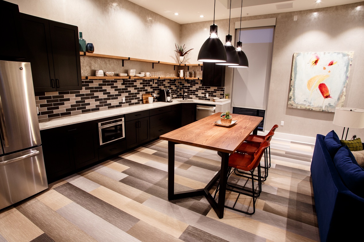 Penthouse kitchen featuring a dining table, refrigerator, dishwasher, microwave and white countertops